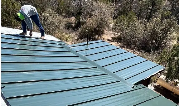 Worker on Metal Roof in Forest